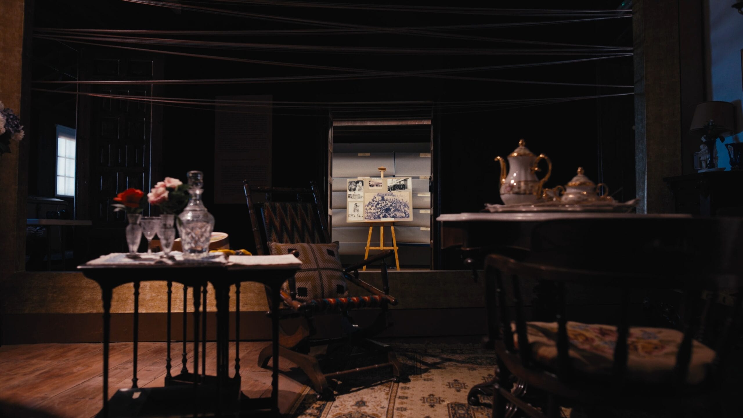 Museos de Tenerife — A painting of a car is displayed on a wall in a room with a chair and a table.