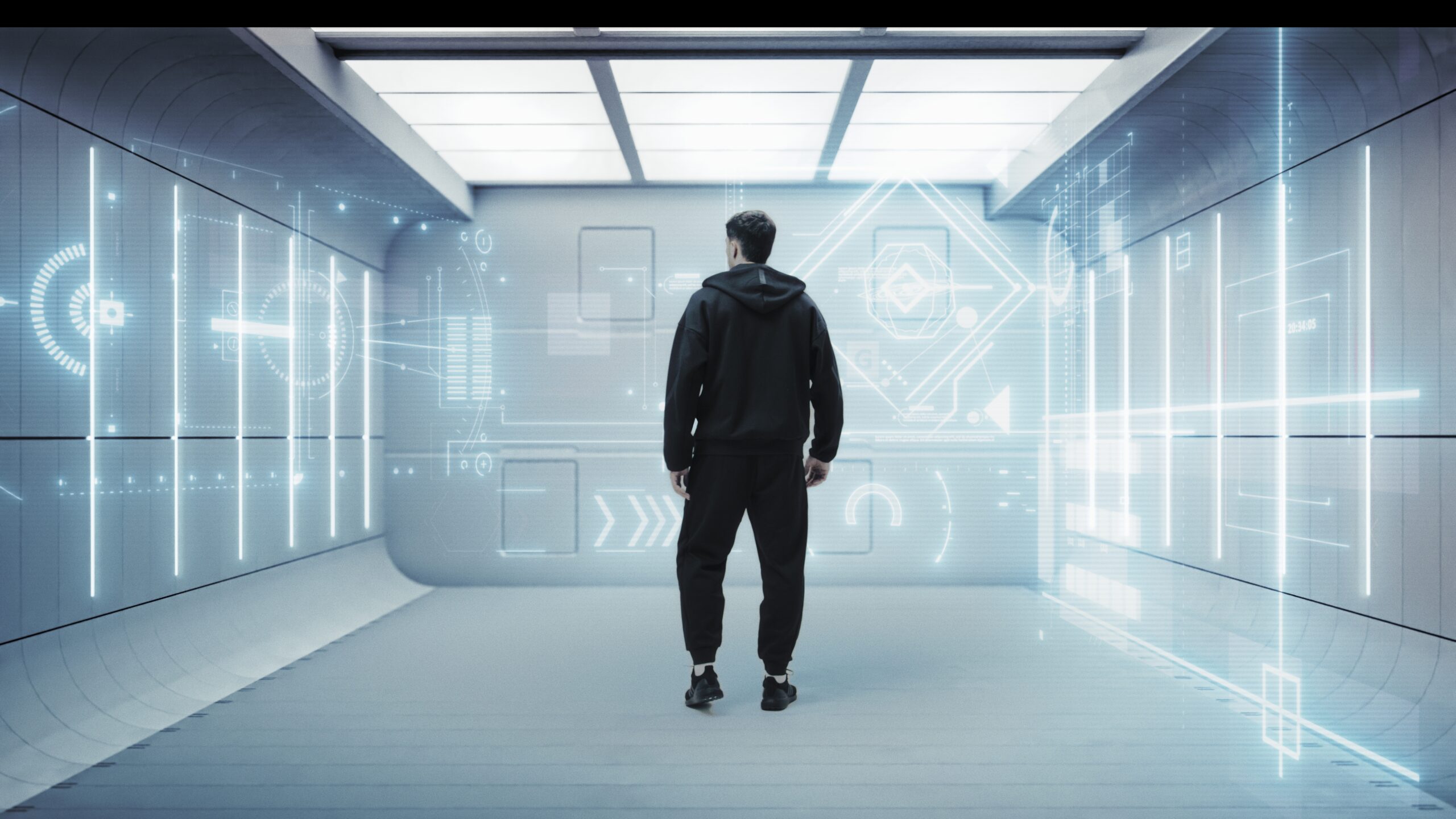 Adidas Metalbone 3.4 — A man wearing a black hoodie and black pants stands in a room with a blue background.