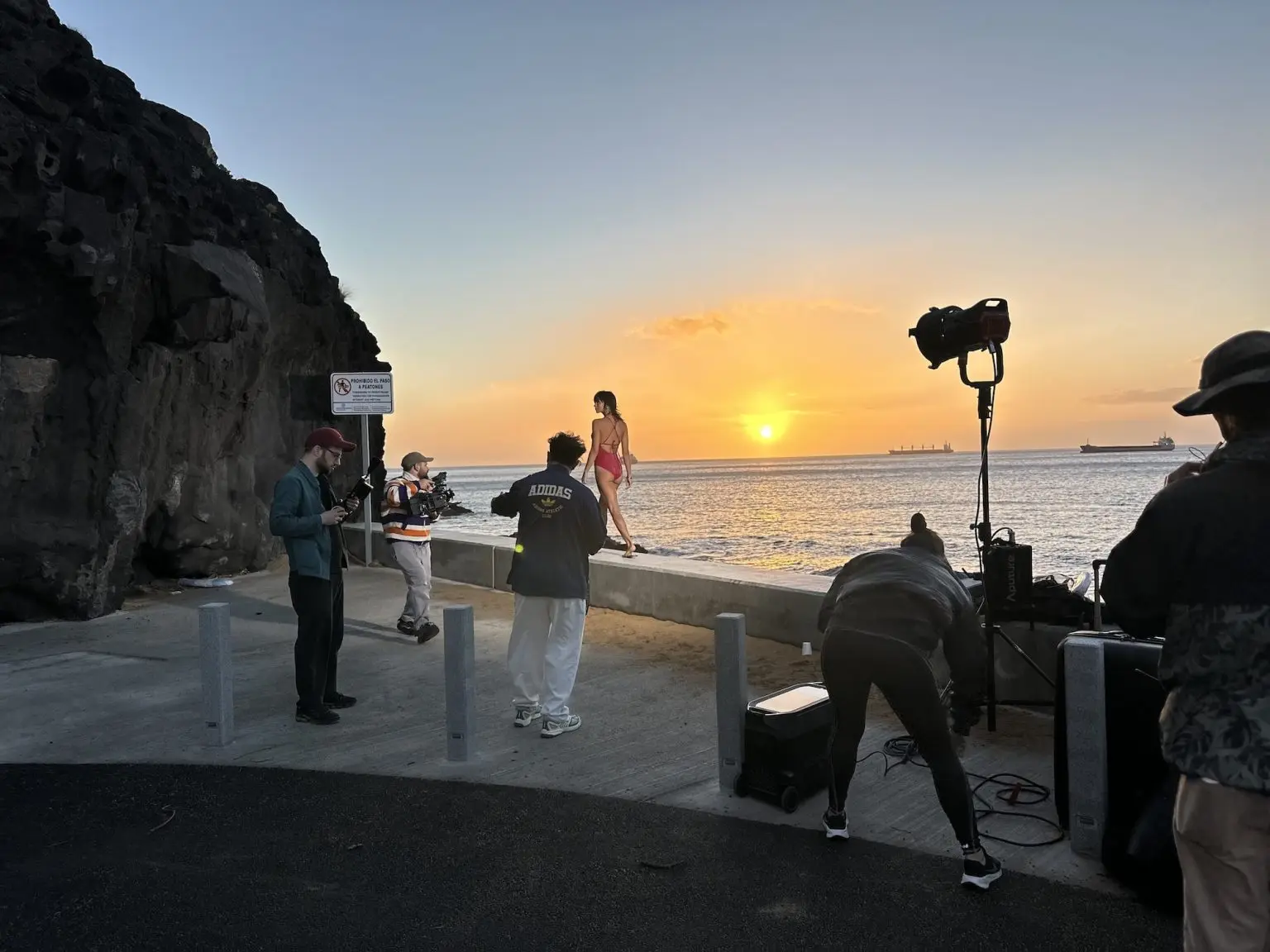 Triumph — Triumph — Film crew and lighting equipment beside the sea at sunset.