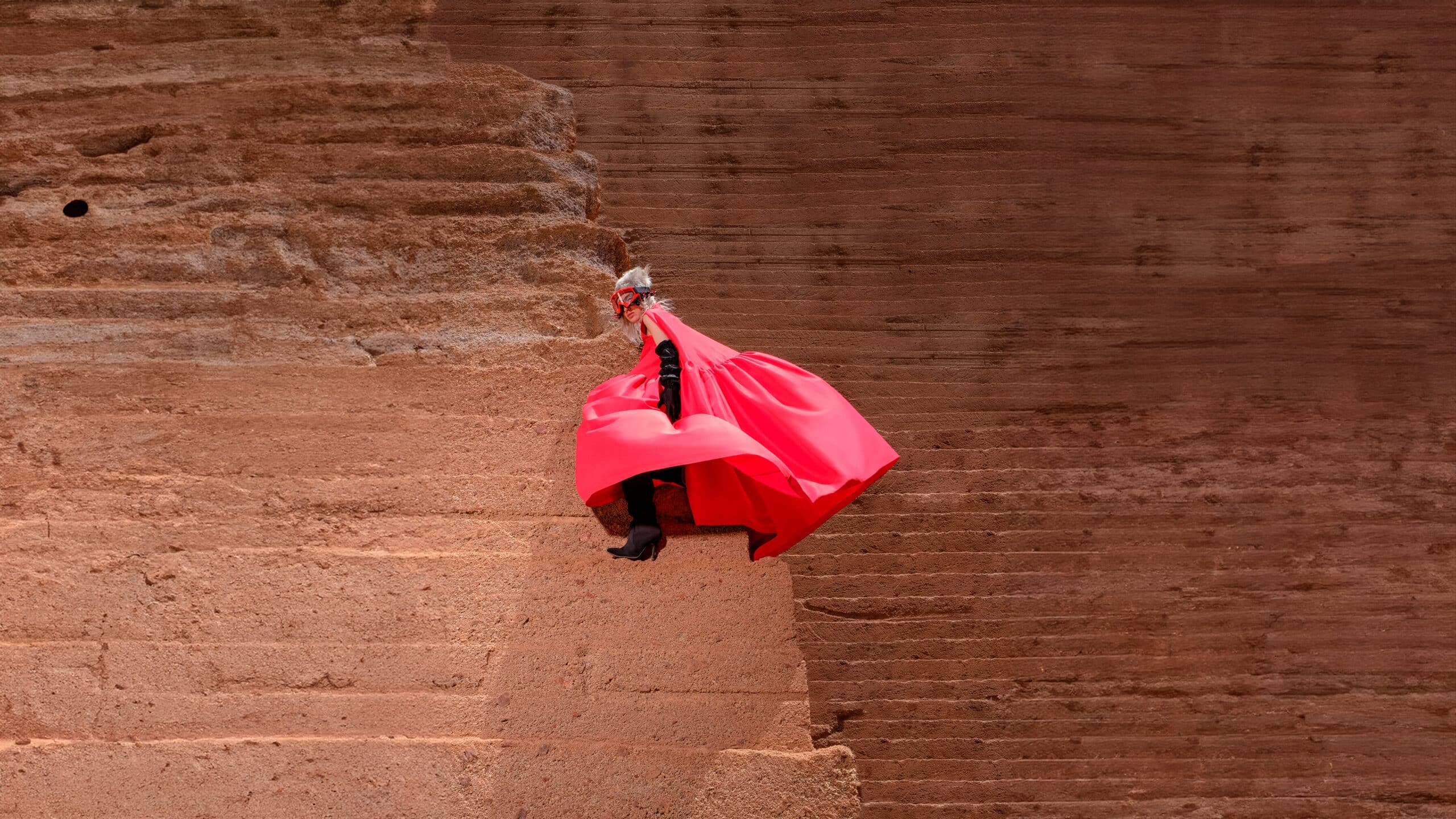 Lava Silhouttes — A person wearing a red cape and hat is flying through the air.