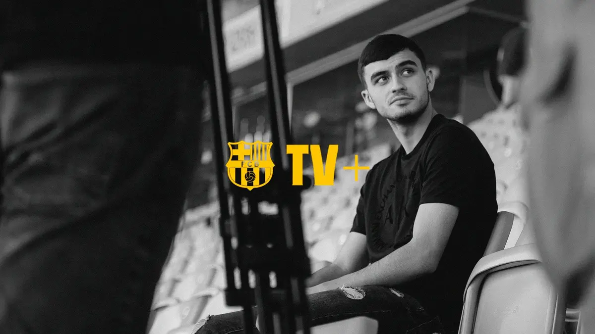 Orígenes — Un hombre con camisa negra y vaqueros sentado en un estadio.